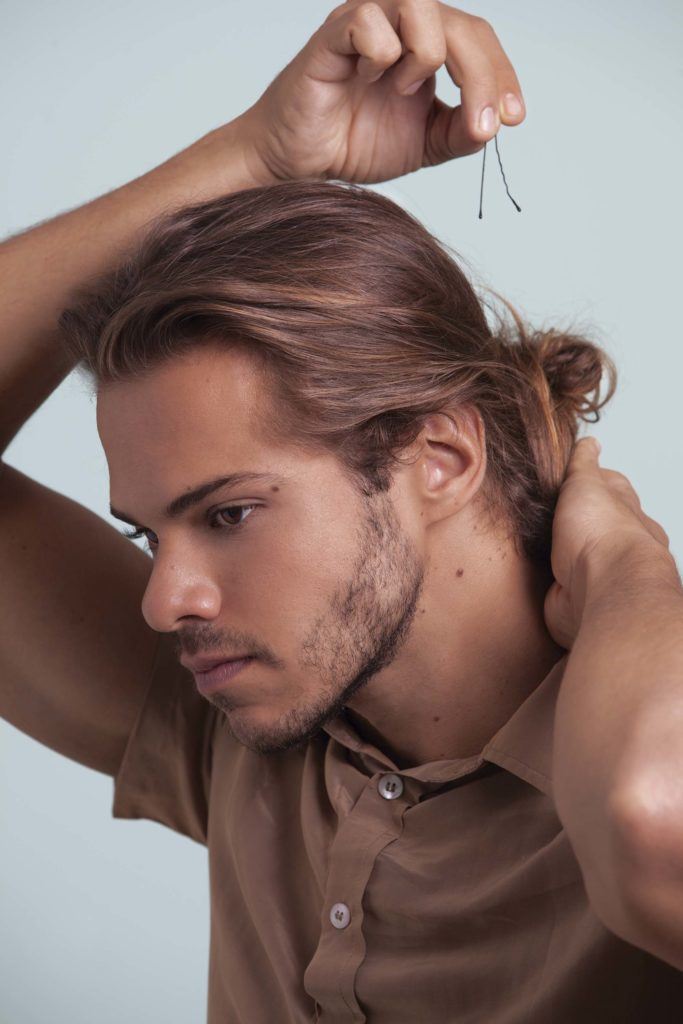 a man with bun hair side looking