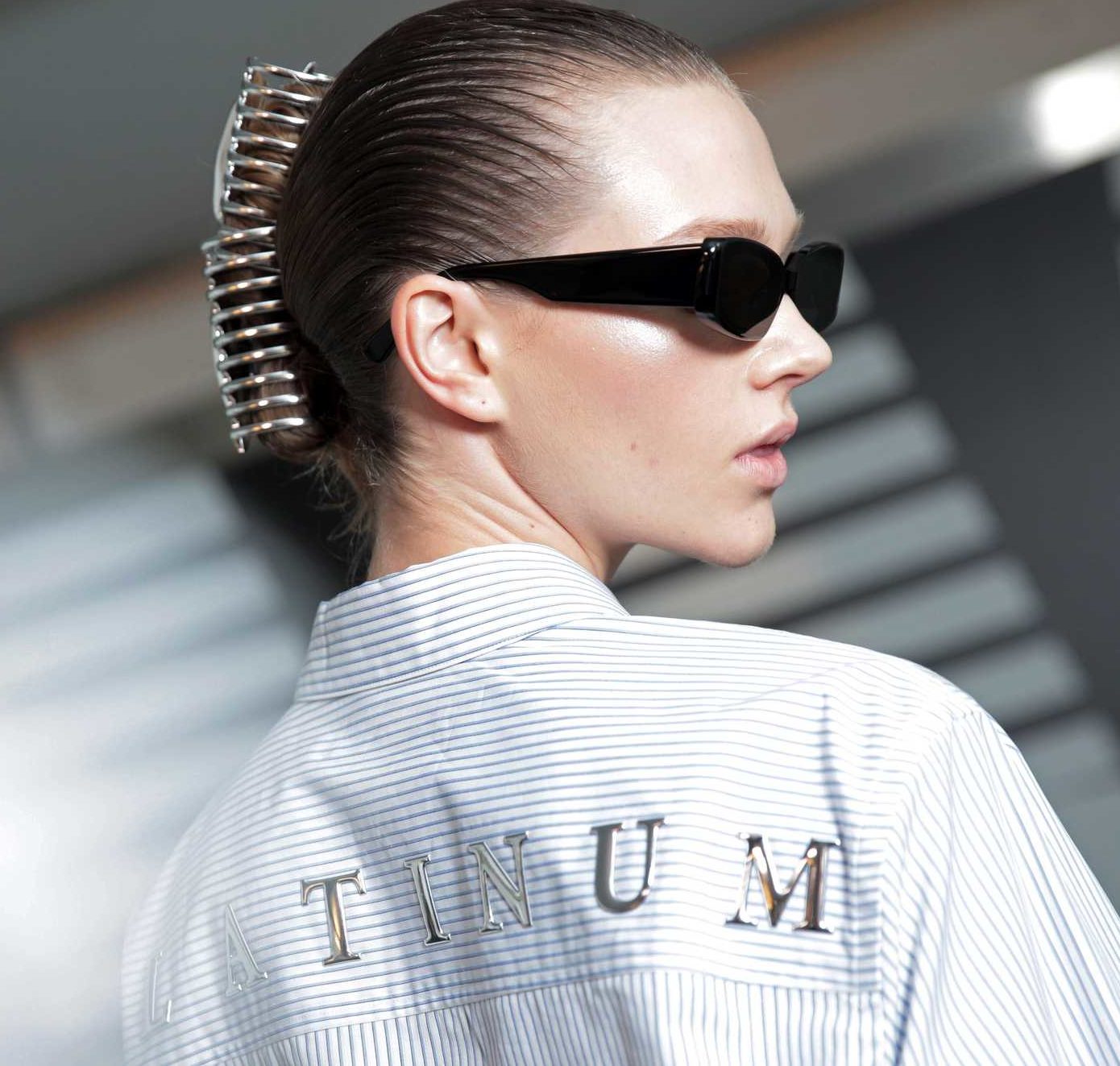 side view of model with light brown wet look hair styled in a easy updo with hair claw accessory