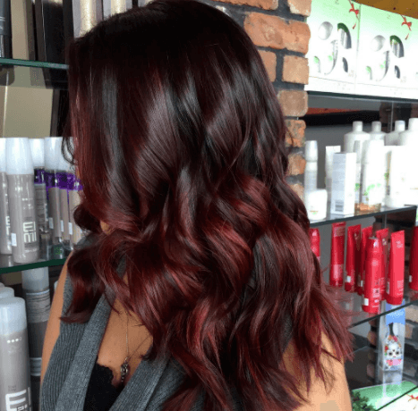 chocolate cherry hair colour: salon shot of women with dark chocolate hair with cherry highlights