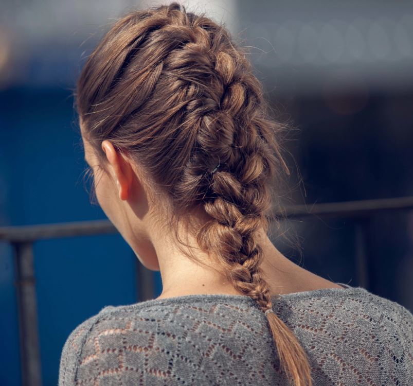 Updos for medium hair: back view of model wit brown hair styled in a single french braid