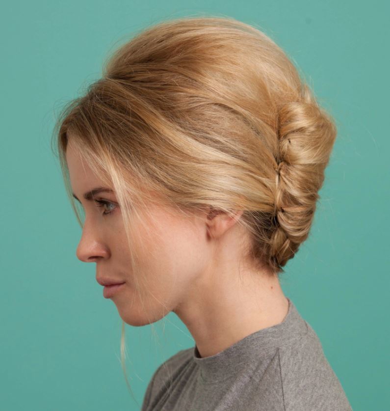 updos for medium hair: side view of model with blonde hair styled ina retro classic french twist