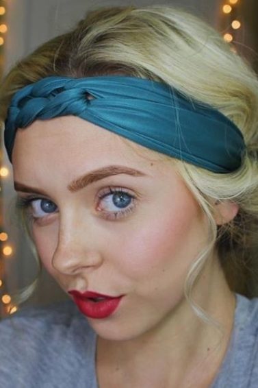 updos for short hair: close up of a blonde woman wearing a teal blue headband with her hair in a tucked updo