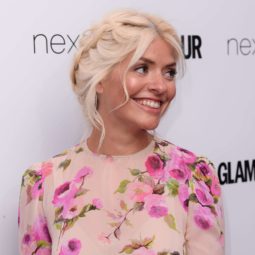 holly willoughby wearing a floral dress at the glamour woman of the year awards with her blonde hair in a braided updo