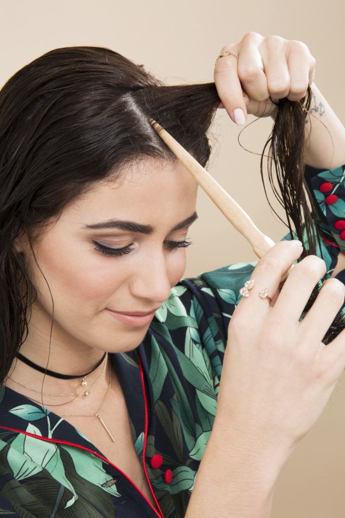 Pin curls tutorial: Dark haired model parting her hair for pin curls