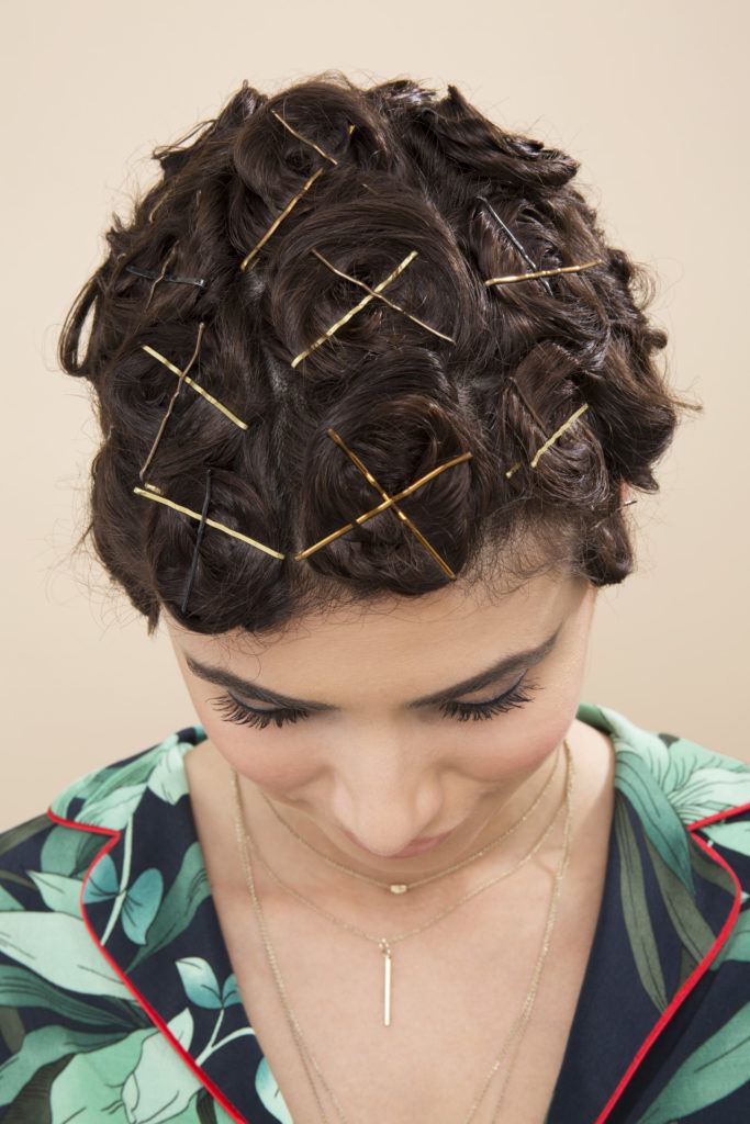 Pin curls tutorial: Brunette model tilting her head down and showing a full head of pinned curls