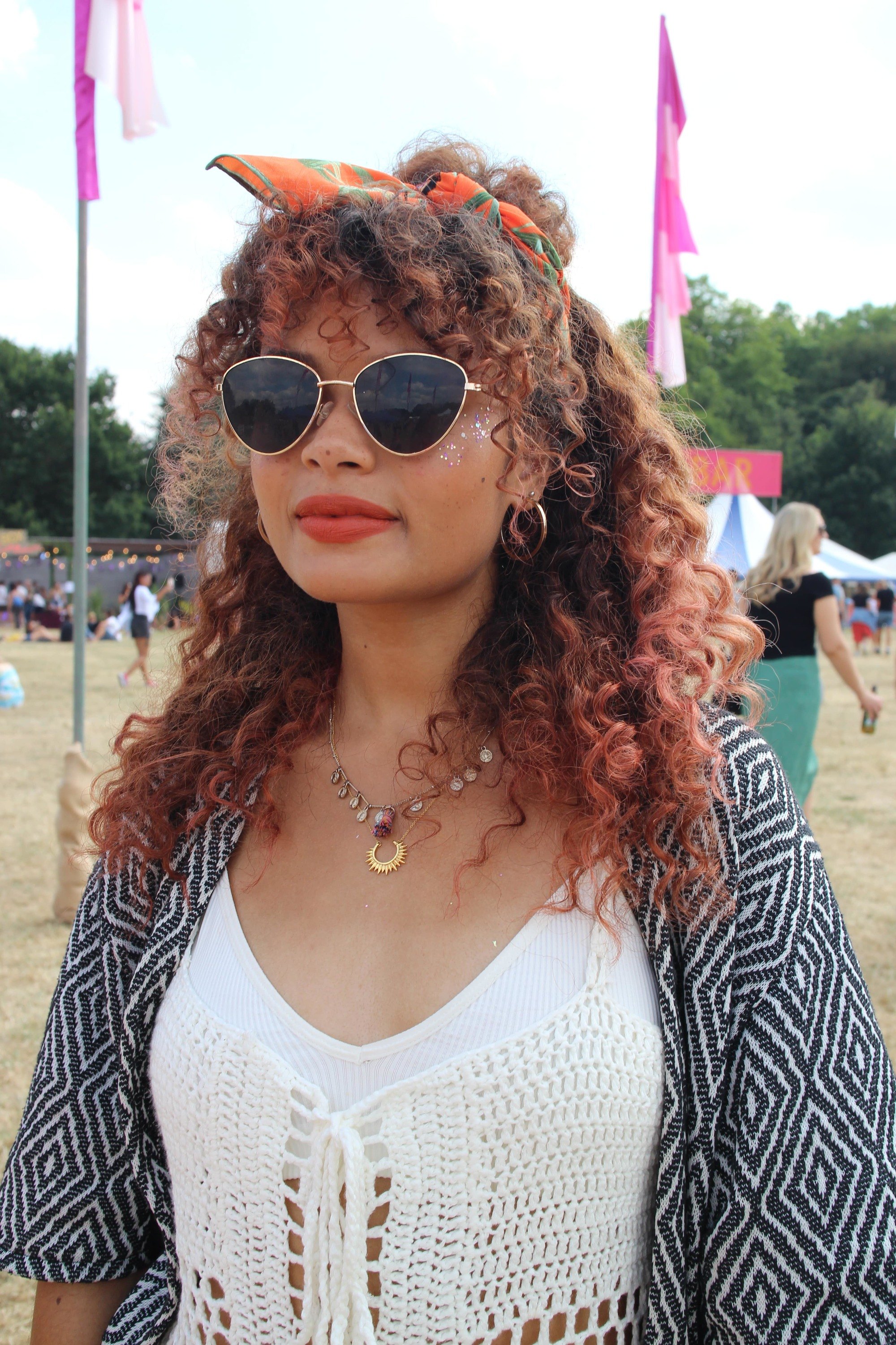 Festival hair accessories: Woman with naturally curly hair styled in a half-up, half-down bun wrapped in a headscarf