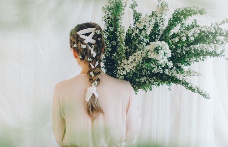 brunette with a ribbon braid holding flowers