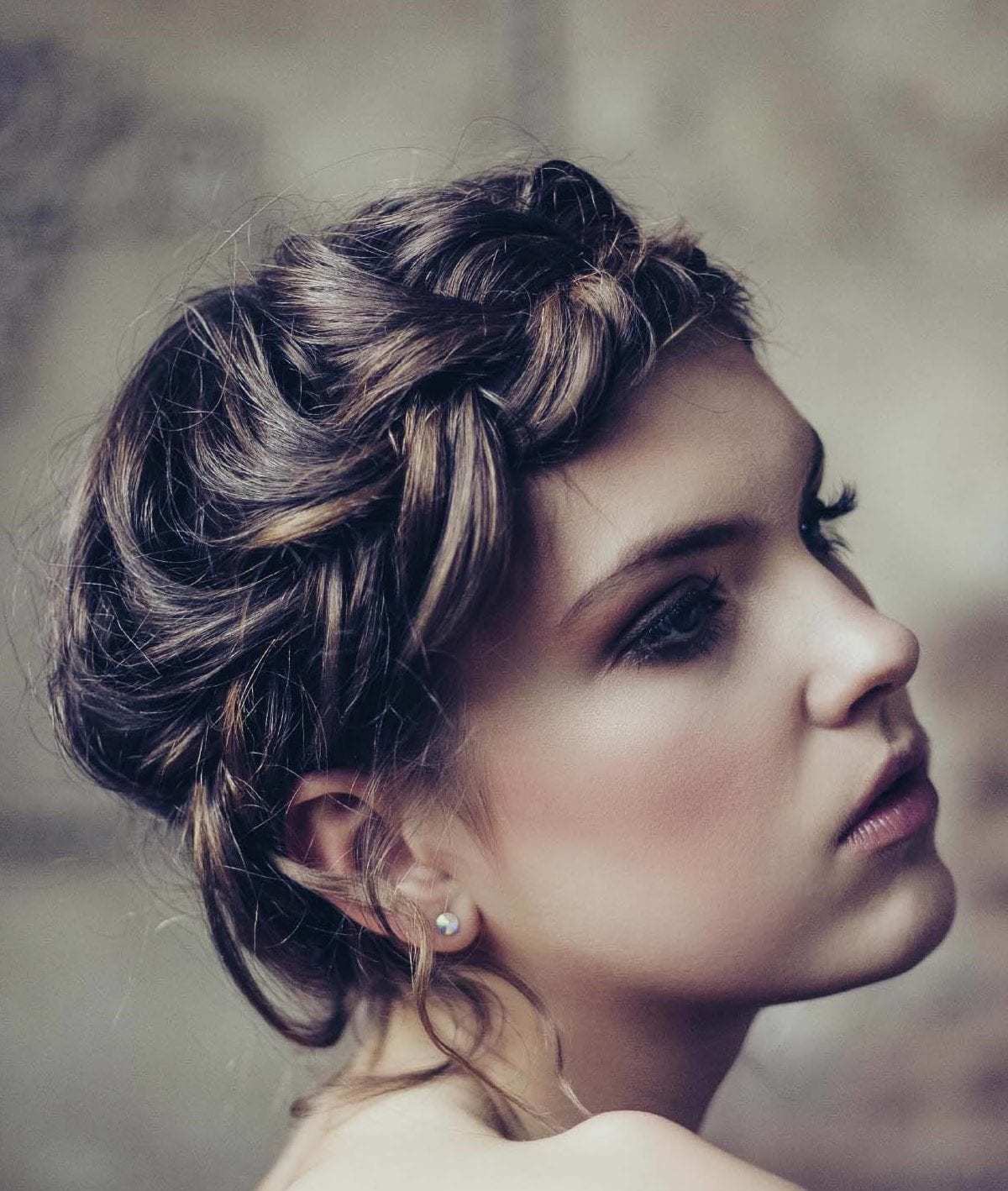updos for medium hair: model with brown hair styled in a messy crown braid