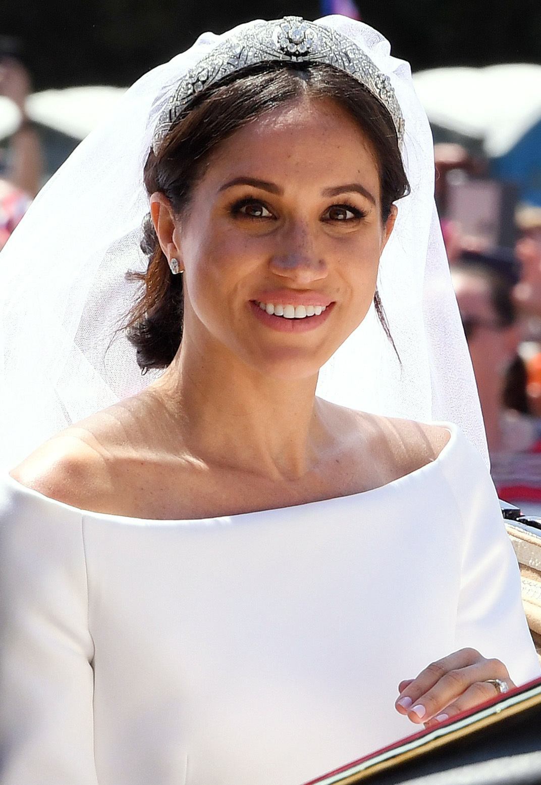Meghan Markle Duchess of Sussex on her wedding day with her dark hair in a low messy bun with a veil and tiara