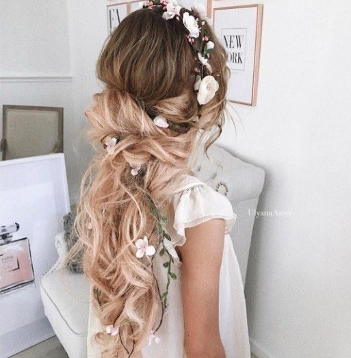 Woman with brown to blonde ombre curly hair with a messy low ponytail hairstyle