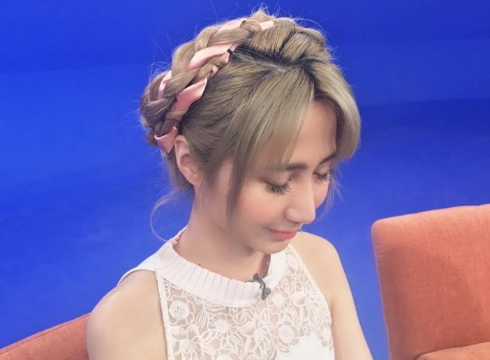 ribbon braids hair trend: women with ribbon weaved through a milkmaid braid