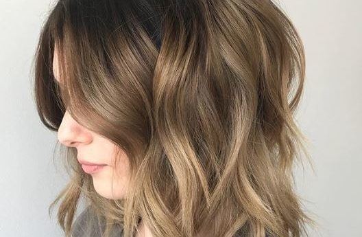 Short ombre hair: Woman with long bob wavy brown soft ombre hair.
