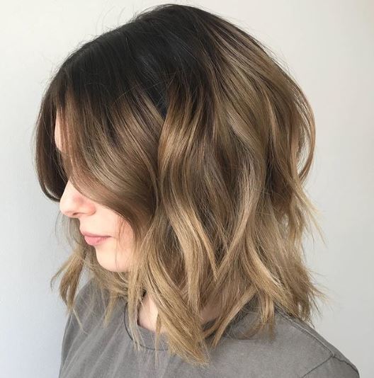 Short ombre hair: Woman with long bob wavy brown soft ombre hair.