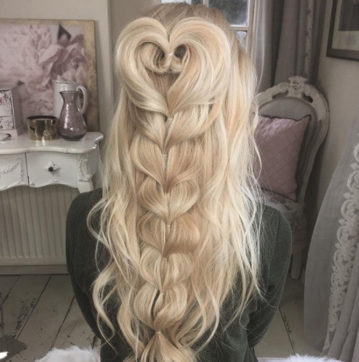 woman with long curly blonde hair in a half-up heart braid
