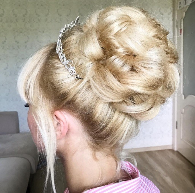 Blonde girl with a high bun updo with a tiara