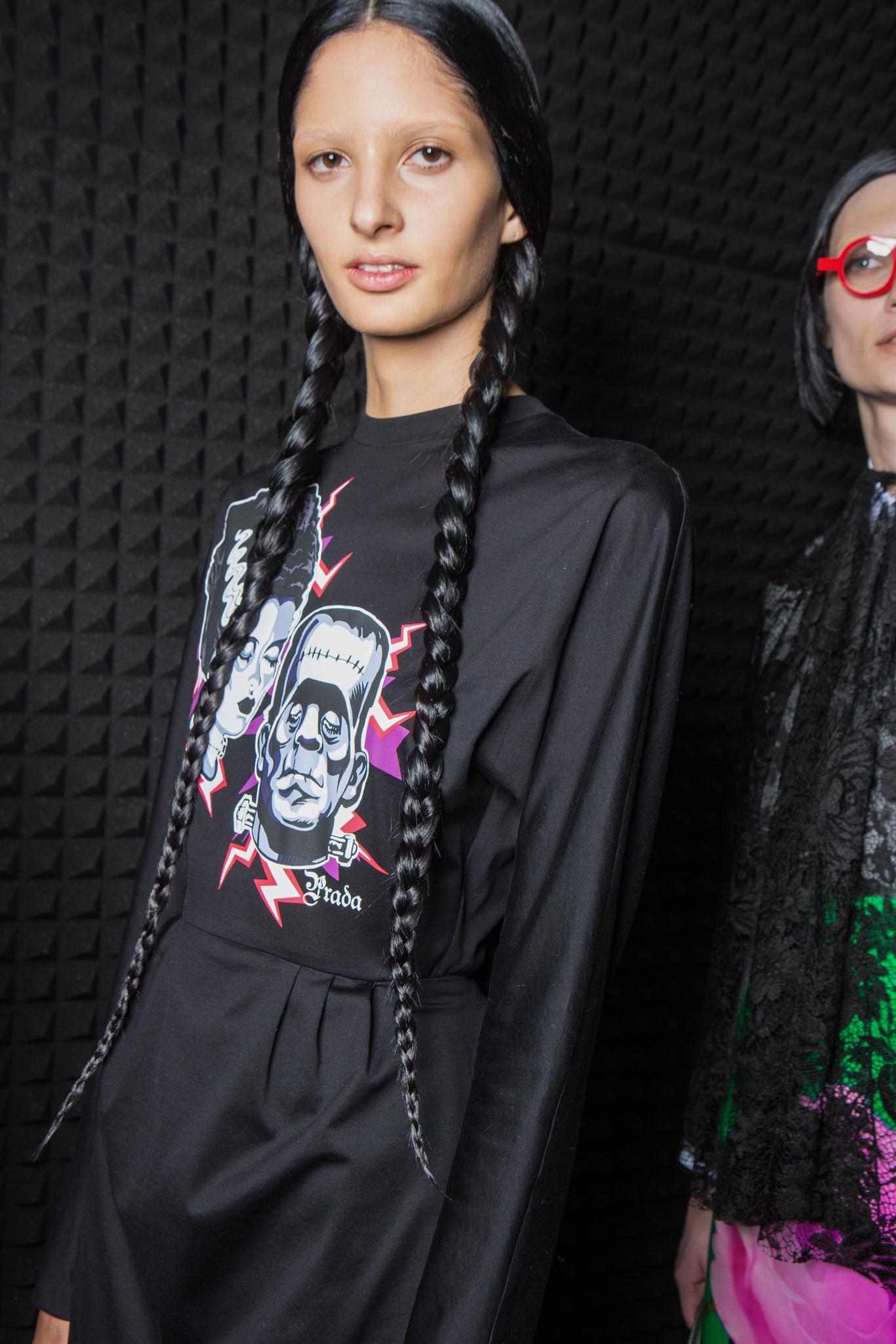 Updos for long hair: Woman with long dark brown hair in pigtail braids at fashion show