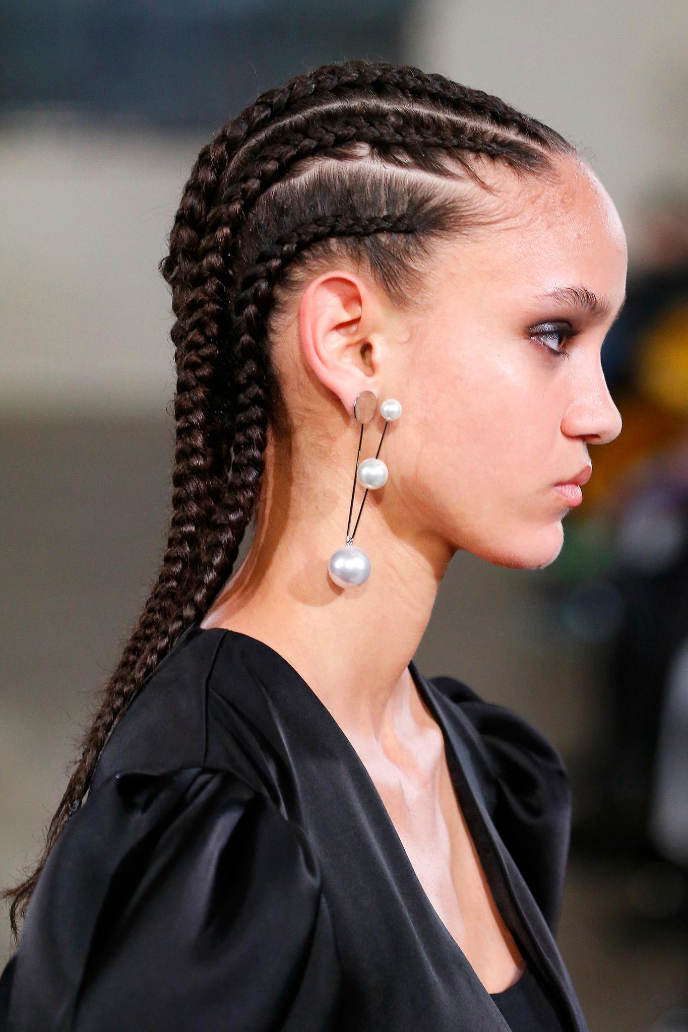 Updos for long hair: Woman with long brown hair in cornrows on runway