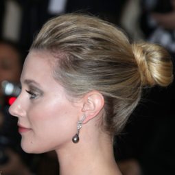 updos for medium hair: side view of lili reinharts blonde hair styled in a medium high bun hairstyle at red carpet event