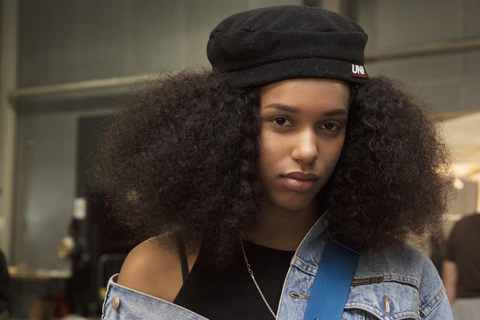 shot of model at afropunk with long afro curls wearing a beret