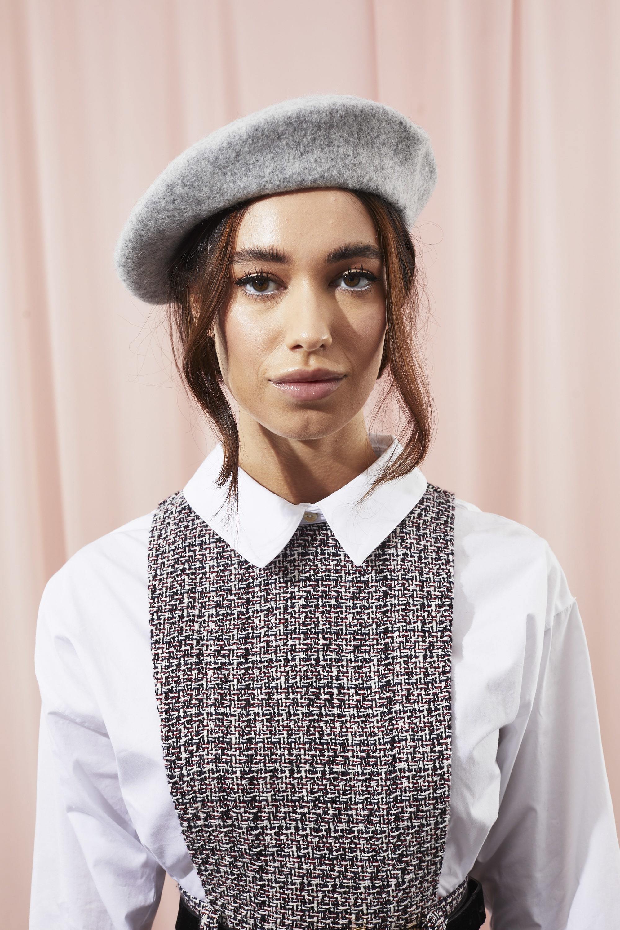 Woman with beret and low updo with face-framing tendrils