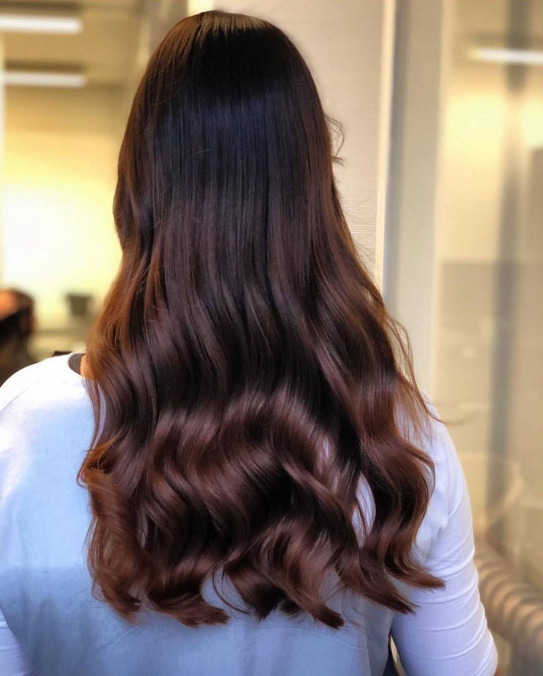 Woman with long glossy mahogany waves
