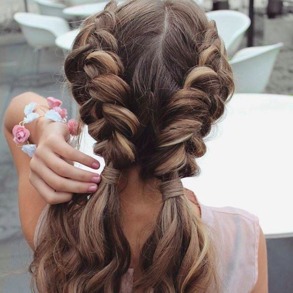 back view of a woman with double dutch braid style into low pigtails