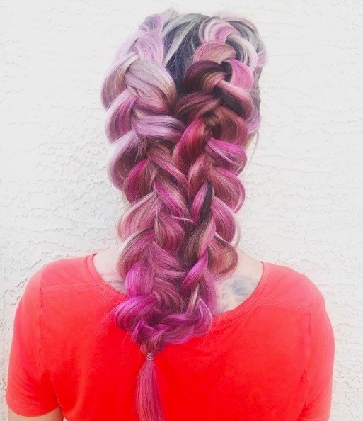 back view of a woman with pink hair in double Dutch braid style