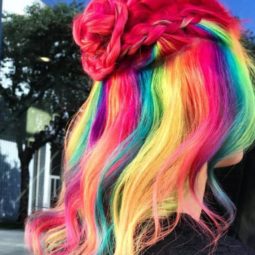woman with froot loops inspired cereal hair styled into a half up braided bun at salon