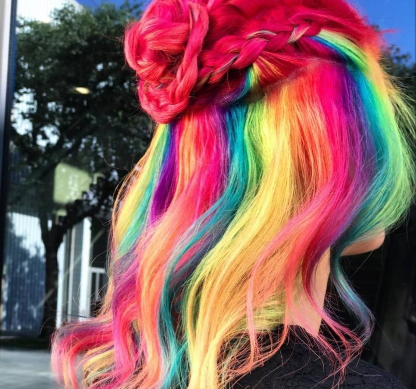 woman with froot loops inspired cereal hair styled into a half up braided bun at salon