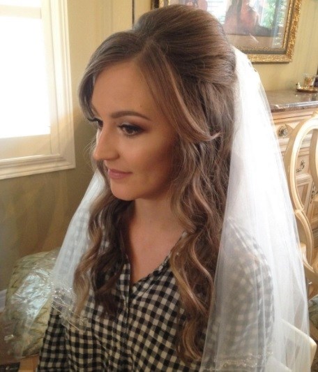 brunette bride with her hair in a half up bouffant hairstyle with a veil