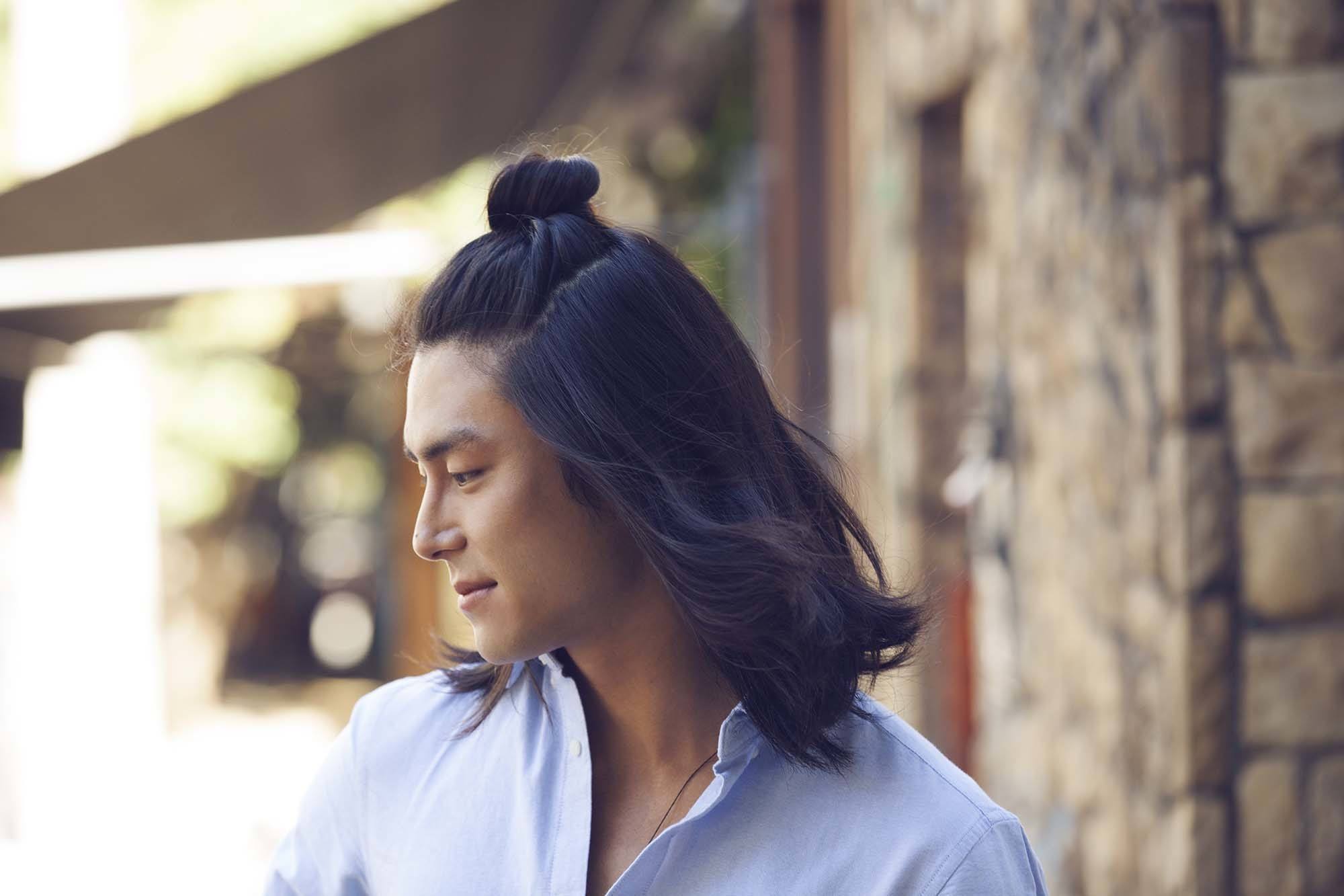 top knot men: male model with half up man bun hairstyle with blue shirt