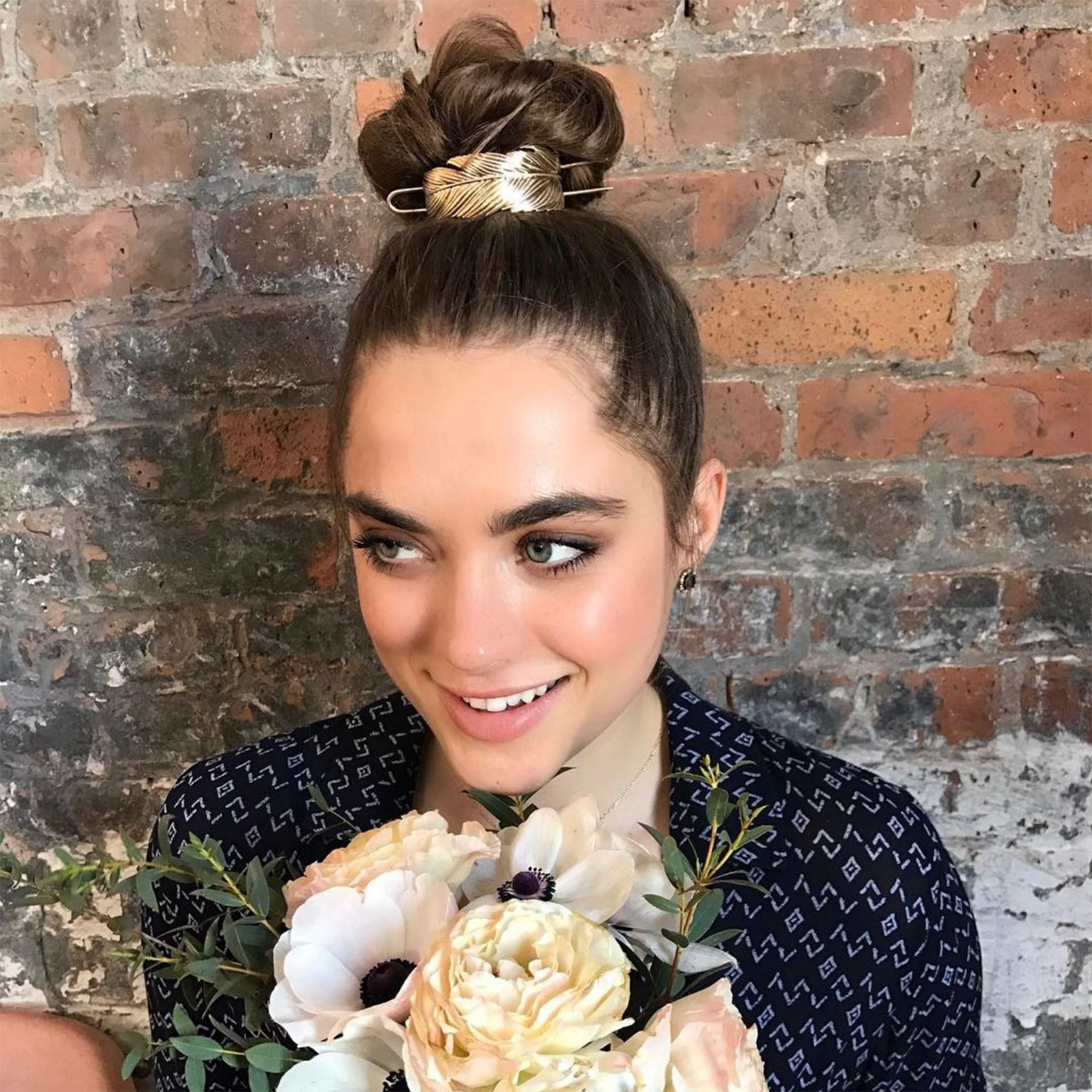 Brown hair in high bun with gold metal hair cuff