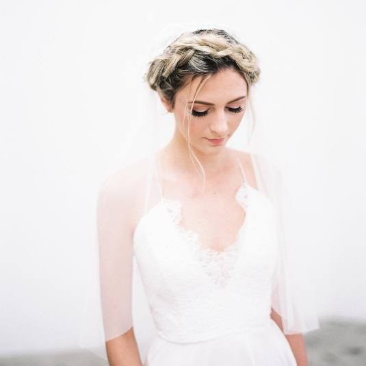 blonde bride with her hair in a milkmaid braid and a veil on top