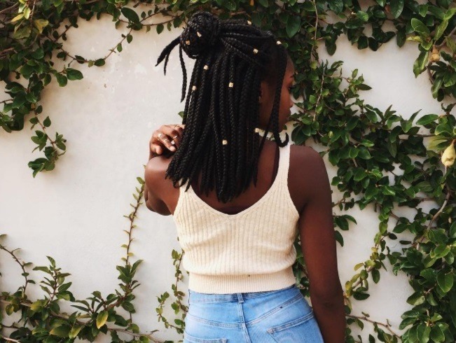 model with short box braids half up hairstyle wearing white shirt
