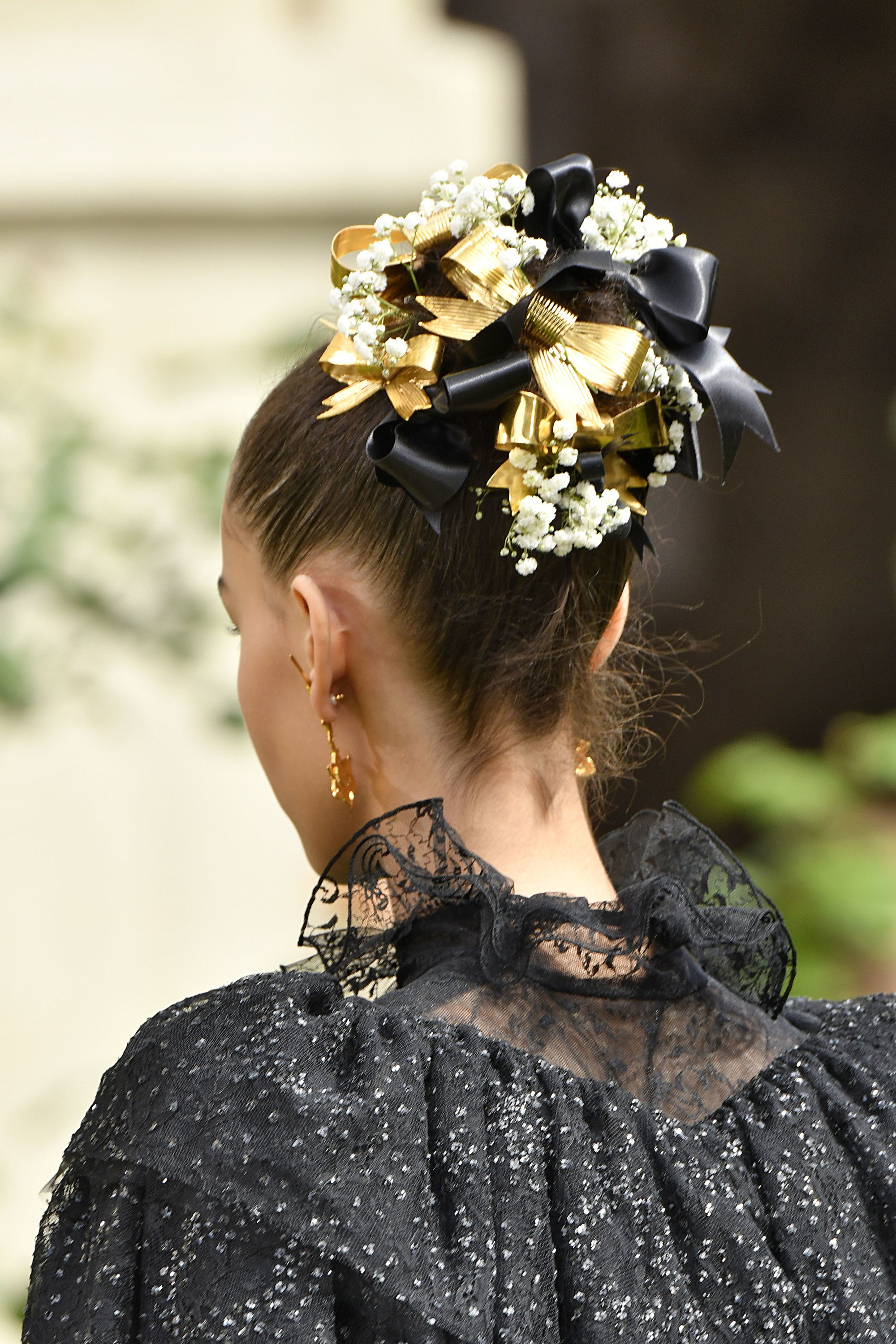 backshot of model with bun adorned with baby's breath and bows on the rodarte runway
