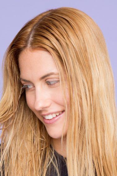 Shampoo full guide: Woman touching her straight blonde hair.