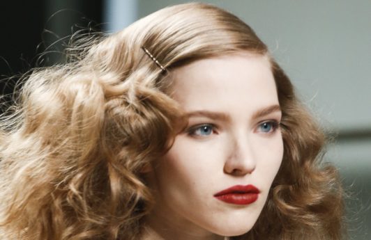 runway shot of a brunette model with 1920s screen siren curly frizzy hair