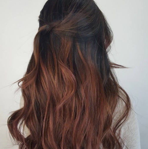 Balayage long hair: back view of a woman with long auburn balayage hair