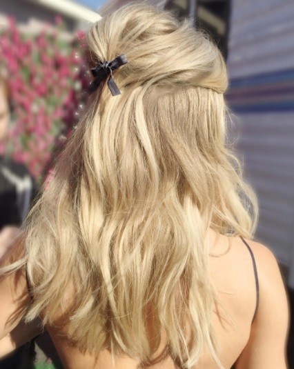 back shot of a woman with blonde hair in a half up bouffant hairstyle
