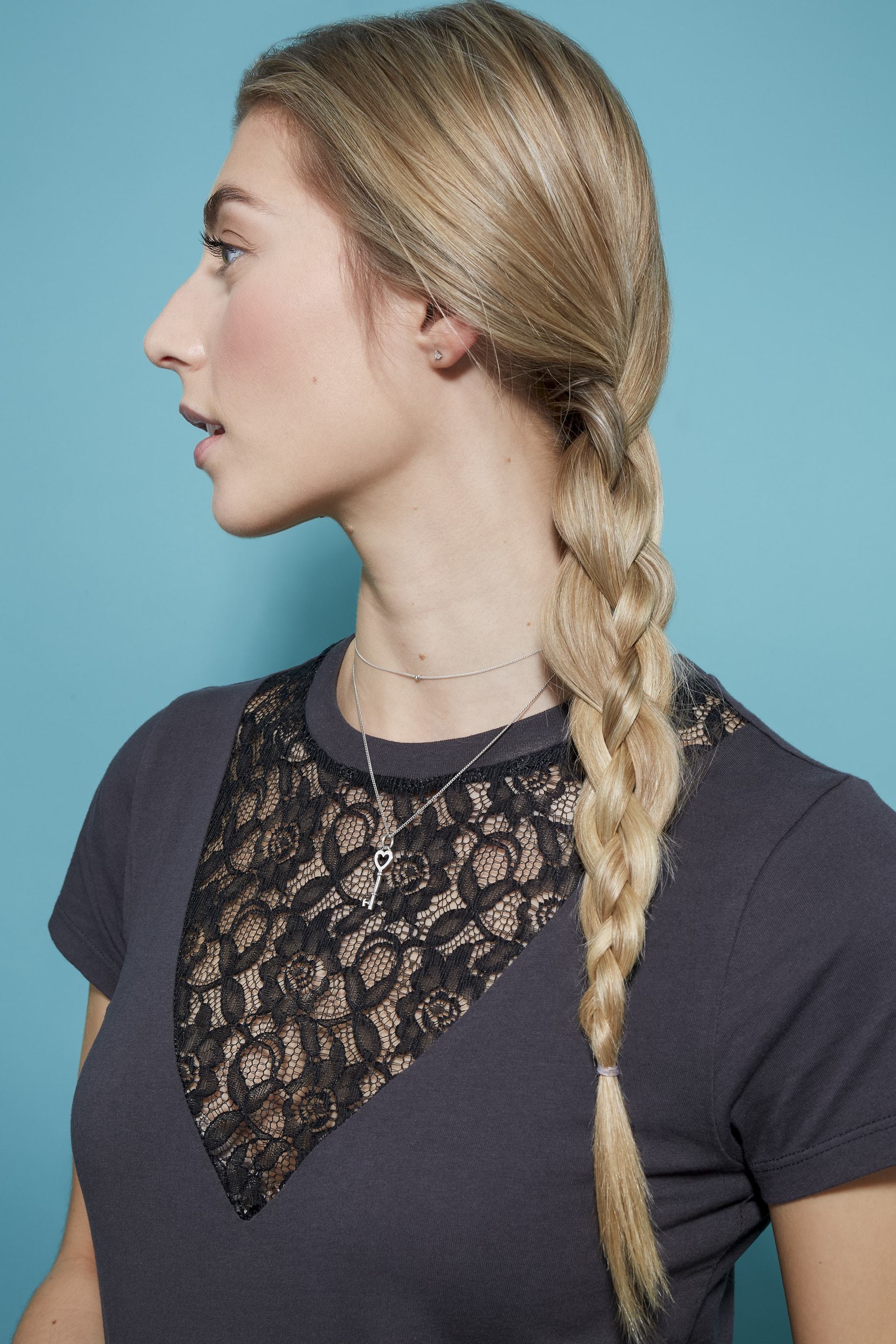 Braids for long hair: Woman with long blonde straight hair in side braid wearing a black top