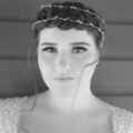 black and white face on photo of a bride with her dark hair in a crown braid updo with a crystal headpiece