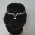 woman with dark brunette hair in an updo style with a crystal headpiece