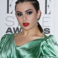 Charli XCX wears her black hair with three braids tied into low ponytail with bold makeup and green dress ar the Elle Style Awards 2016