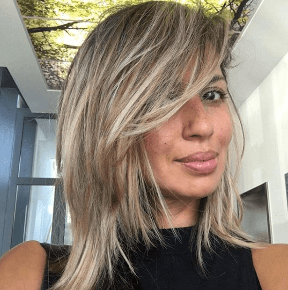 shoulder length ash brown hair with blonde toned chunky highlights swept across the face