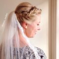 blonde bride wearing a veil with her hair in a fishtail braided updo