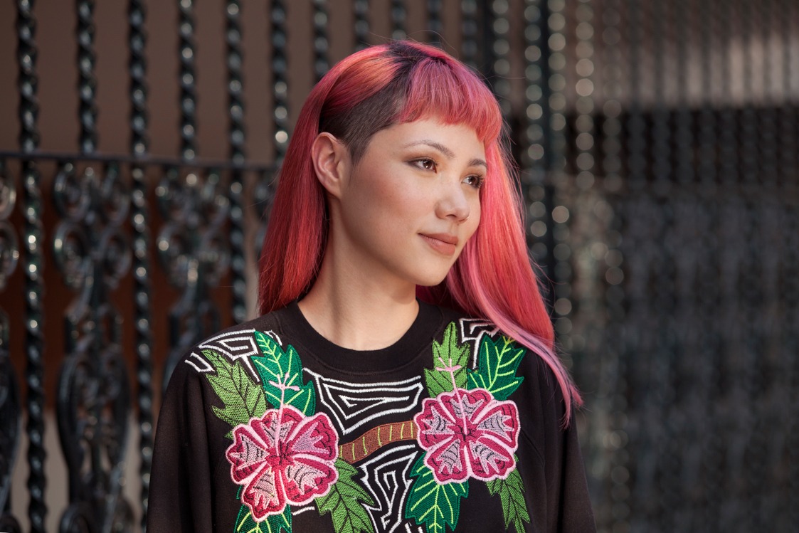 Best hair serum for dry hair: Model with neon pink coloured hair wearing floral jumper outside.