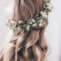 Blonde hair in crown braid half-up, half-down hairstyle with floral detailing