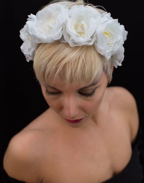 Light platinum blonde pixie cut with white floral headband