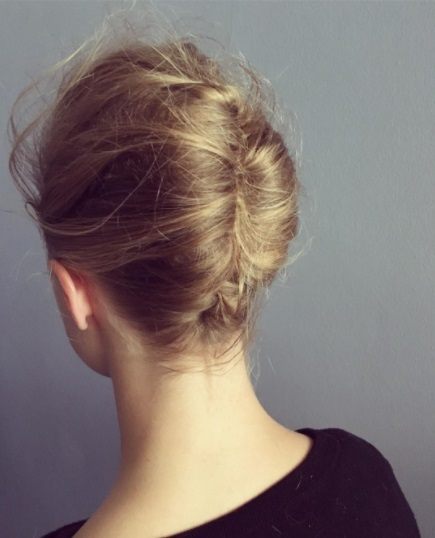 back view of a blonde woman with a french twist updo hairstyle