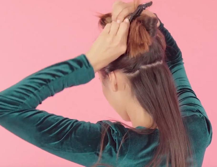 back shot of brunette model sectioning her hair